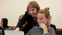 Professor assisting student at laptop